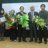 Chủ tịch Hội Nhà văn Hà Nội trao giải cho những tác giả đoạt giải. (Ảnh: Thiên Linh/ Vietnam+).