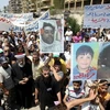 Người biểu tình mang theo ảnh của những người bị lực lượng an ninh bắn chết (Nguồn: Reuters)