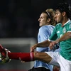Pha tranh bóng của Forlan với một cầu thủ Mexico (Nguồn: Reuters)