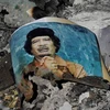 Một tấm ảnh ông Gaddafi bị đốt cháy ở Sirte (Nguồn: Reuters)