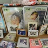 Album ảnh của một em bé thiệt mạng trong thảm họa kép được người thân đặt trên mộ của bé (Nguồn: AFP)