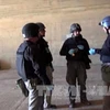 Các thanh sát viên thuộc OPCW làm việc tại một cơ sở không được tiết lộ ở Syria. AFP-TTXVN