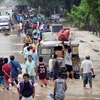 Người dân Philipines sơ tán tới những khu vực cao hơn sau khi 10 ngôi làng ở tỉnh Zambales bị chìm ngập trong nước lũ do mưa lớn khiến một con đập bị vỡ ngày 8/8. (Ảnh: AFP/TTXVN) 