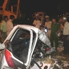 Hiện trường vụ tai nạn và lực lượng cứu hộ đang khẩn trương đưa thi thể các nạn nhân ra khỏi xe. (Ảnh Văn Sơn/TTXVN)