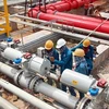Các kỹ sư, công nhân nhà máy lọc dầu Dung Quất đang chỉnh sửa đường ống xuất sản phẩm. (Ảnh: Nguyễn Đăng Lâm/TTXVN) 