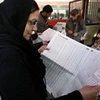 Một phụ nữ đang xem danh sách ứng cử viên bị cáo buộc liên quan đến đảng Baath. (Ảnh: AFP)