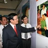 Chủ tịch nước Trương Tấn Sang xem các hình ảnh tại triển lãm. (Ảnh: Nguyễn Khang/TTXVN) 