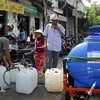 Điểm đổ nước của tư nhân cho người dân mua trên đường Huỳnh Tấn Phát, quận 7. (Ảnh: Hoàng Hải/TTXVN)