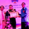 Đại diện Ngân hàng Sacombank Chi nhánh Lào nhận bằng khen. (Ảnh: Hoàng Chương/Vietnam+) 