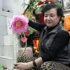 "Nữ hoàng hoa lụa" bên tác phẩm sen lụa nổi tiếng thương hiệu Mai Hạnh. (Ảnh: Thanh Hương/ Vietnam+)