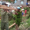 Lực lượng vũ trang và đoàn viên thanh niên tham gia dỡ dọn và dựng lại nhà ở cho nhân dân ở Kon Tum. (Ảnh: Đoàn Hữu Trung/TTXVN) 