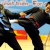 Vận động viên Nguyễn Bá Trình (Việt Nam, bên phải) thắng Agus Triono (Indonesia), đoạt huy chương vàng ở hạng cân 60kg pencak silat. (Ảnh: Thanh Hà/TTXVN) 