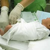 Lấy máu gót chân để xét nghiệm, phát hiện dị tật bẩm sinh cho trẻ sơ sinh tại Bệnh viện Phụ sản Trung ương. (Ảnh: Dương Ngọc/TTXVN)