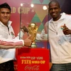 Cầu thủ Phan Thanh Bình và cầu thủ người Nam Phi Philani bên chiếc Cúp vàng tại buổi họp báo tối ngày 18/1. (Ảnh: Quang Nhật/TTXVN)