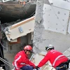Nhân viên cứu hộ tìm kiếm các nạn nhân trong những đống đổ nát sau trận động đất ở Concepcion. (Ảnh: AFP/TTXVN)