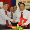 Tổng giám đốc TTXVN Trần Mai Hưởng (trái) và Chủ tịch Ủy ban Nhân dân tỉnh Cà Mau Bùi Công Bửu ký thỏa thuận. (Ảnh: Tràng Dương/TTXVN) 