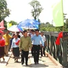 Phó Thủ tướng Lào Somsavad Lengsavad và nhân dân tỉnh đang đi bộ qua cầu Xêxụ trong ngày khánh thành công trình. (Ảnh: Phạm Văn Kiên/TTXVN)