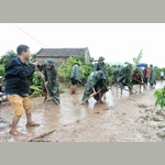 Phóng viên Danh Lam, Cơ quan thường trú Bắc Giang, tác nghiệp tại hiện trường khắc phục hậu quả mưa lũ tại thôn Khả Lã, xã Tân Lập, Lục Ngạn, Bắc Giang. (Ảnh: TTXVN)