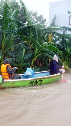 Người dân các địa phương huyện Lệ Thủy (Quảng Bình) dùng thuyền di chuyển trong vùng bị ngập lụt. (Ảnh: Tá Chuyên/TTXVN)