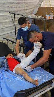 Điều trị cho em nhỏ bị thương tại bệnh viện tạm ở thành phố Khan Younis, phía Nam Dải Gaza (Ảnh: THX/TTXVN)