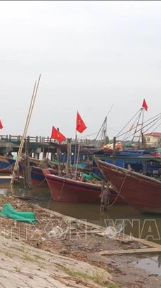 Chiến sỹ Đồn Biên phòng Kim Sơn, huyện Kim Sơn, tỉnh Ninh Bình thông báo về tình hình bão cho ngư dân. (Ảnh: Thùy Dung/TTXVN)