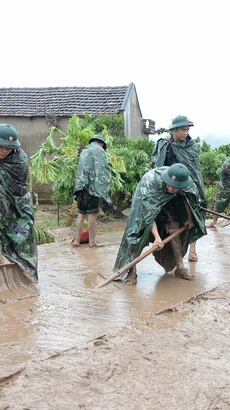 Phóng viên Danh Lam, Cơ quan thường trú Bắc Giang, tác nghiệp tại hiện trường khắc phục hậu quả mưa lũ tại thôn Khả Lã, xã Tân Lập, Lục Ngạn, Bắc Giang. (Ảnh: TTXVN)