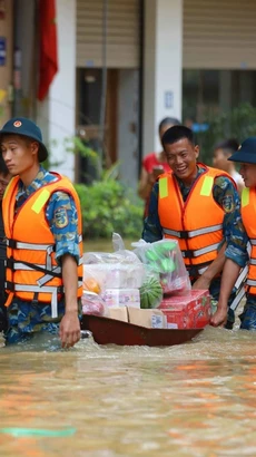 Lực lượng Quân đội, Công an, dân quân giúp dân xã Bát Tràng, huyện Gia Lâm (Hà Nội) di chuyển ra khỏi vùng ngập lụt. (Ảnh: Thanh Tùng/TTXVN)