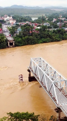 Sự cố sập cầu Phong Châu xảy ra ngày 9/9, do lũ trên sông Thao (sông Hồng) lên rất cao, chảy xiết, cuốn trôi trụ T7 và hai nhịp dàn chính (nhịp 6 và nhịp 7 phía bờ hữu sông Thao, thuộc địa bàn huyện Tam Nông). (Ảnh: Tạ Toàn/TTXVN)