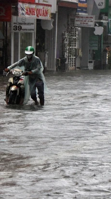 Nước ngập tại nhiều tuyến đường trong thành phố Huế khiến việc đi lại của người dân khó khăn. (Ảnh: Đỗ Trưởng/TTXVN)