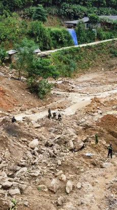 Lực lượng công an, quân đội cùng máy móc cơ giới nỗ lực, khẩn trương tìm kiếm các nạn nhân đang mất tích. (Ảnh: Hoàng Hiếu/TTXVN)