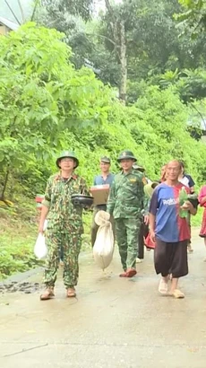 Lực lượng chức năng hỗ trợ người dân huyện Mường Lát (Thanh Hóa) sơ tán đến nơi an toàn. (Ảnh: TTXVN phát)