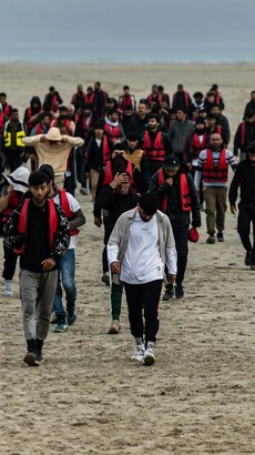 Dòng người di cư trên bờ biển Gravelines, miền Bắc Pháp. (Ảnh: AFP/TTXVN)