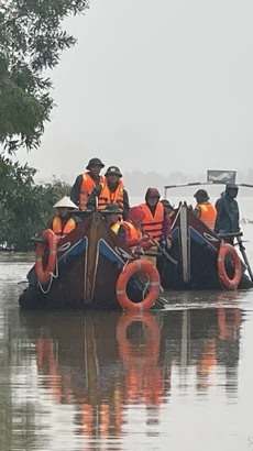 Các lực lượng chức năng di chuyển bằng thuyền hỗ trợ người dân vùng ngập lụt. (Ảnh: Thanh Thủy/TTXVN)