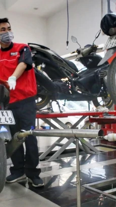 Nhân viên kiểm tra khí thải tại một cơ sở bảo dưỡng, sửa chữa xe máy. (Ảnh: Tuấn Đức/TTXVN)