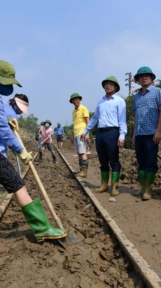 Nhân viên đường sắt dọn dẹp bùn trong khu vực ray tàu hỏa để thông tuyến, chạy tàu trở lại. (Ảnh: PV/Vietnam+)