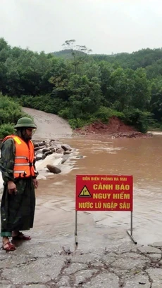 Lực lượng Đồn Biên phòng Ra Mai (huyện Minh Hóa, Quảng Bình) chốt chặn không cho người dân qua các ngầm tràn khi nước lũ dâng cao. (Ảnh: TTXVN phát)