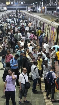 Người đi làm bị mắc kẹt tại Chhatrapati Shivaji Terminus trong trận mưa lớn ở Mumbai, Ấn Độ ngày 25/9. (Ảnh: AP)