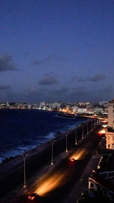 Những chiếc ôtô chạy trên đại lộ ven biển Malecon khi thủ đô Havana bị mất điện ngày 20/10. (Ảnh: Reuters)