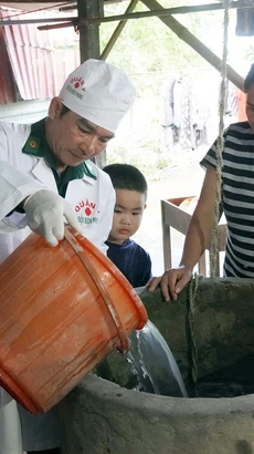 Quân y Bộ đội Biên phòng tỉnh Quảng Bình hỗ trợ người dân vùng lũ huyện Lệ Thủy khử khuẩn nguồn nước sinh hoạt. (Ảnh: TTXVN phát)