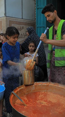 Các em nhỏ nhận thực phẩm cứu trợ tại thành phố Rafah, Dải Gaza, ngày 28/4/2024. (Ảnh: THX/TTXVN)