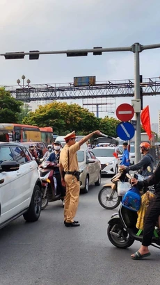 Lực lượng Cảnh sát giao thông nỗ lực điều tiết, hướng dẫn các phương tiện di chuyển. (Ảnh: TTXVN phát)