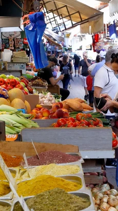 Người dân mua sắm tại một khu chợ ở thành phố Tel Aviv, Israel. (Ảnh: AFP/TTXVN)