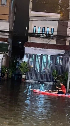 Người dân phải dùng thuyền để di chuyển tại khu vực ngã ba cống trên đường Thích Quảng Đức, thành phố Thủ Dầu Một, tỉnh Bình Dương. (Ảnh: TTXVN phát)