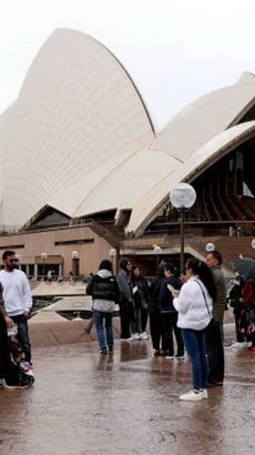 Khách du lịch tham quan khu vực Nhà hát Opera ở Sydney, Australia. (Ảnh: Getty Images/TTXVN)