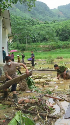 Người dân địa phương nỗ lực tìm người thân bị nạn sau lũ dữ. (Ảnh: Hồng Ninh/TTXVN)