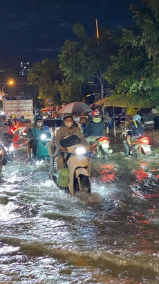 Các phương tiện di chuyển khó khăn khi triều cường gây ngập trên đường Trần Xuân Soạn, quận 7. (Ảnh: Hồng Giang/TTXVN)