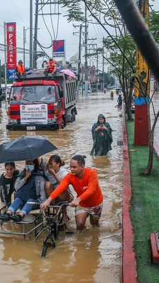 Người dân sơ tán khỏi vùng ngập lụt sau những trận mưa lớn do ảnh hưởng của bão Yagi tại tỉnh Rizal, Philippines. (Ảnh: THX/TTXVN)