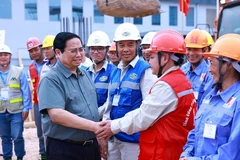 Thủ tướng Phạm Minh Chính với công nhân thi công dự án. (Ảnh: Dương Giang/TTXVN)