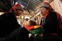 Niềm cui của cô đỡ Lỹ Thị Tìn khi đến giúp bà con trong xã Ngam La, huyện Yên Minh. (Ảnh: Minh Quyết/TTXVN)