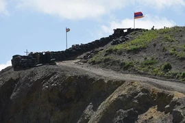 Quốc kỳ Azerbaijan (trái) và quốc kỳ Armenia tại trạm kiểm soát biên giới giữa hai nước ở làng Sotk (Armenia). (Ảnh: AFP/TTXVN) 